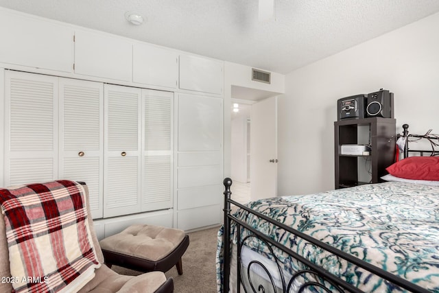 carpeted bedroom with a closet and a textured ceiling