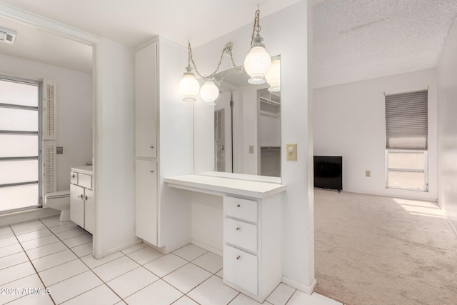 bathroom with vanity, toilet, tile patterned flooring, and a textured ceiling