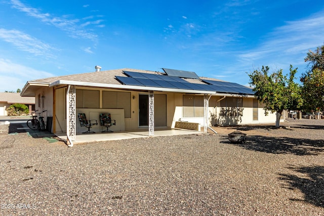 view of front of property featuring a patio and solar panels