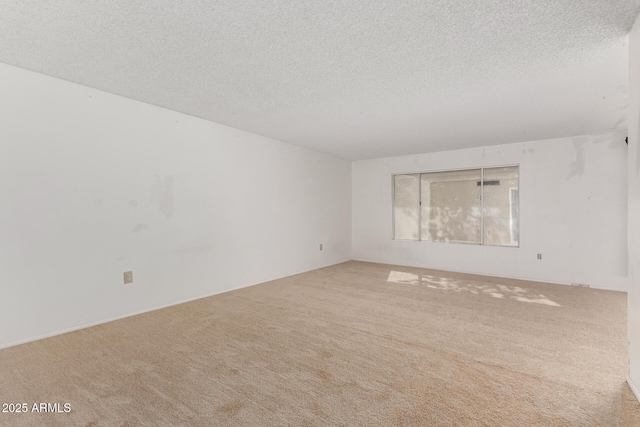 carpeted empty room featuring a textured ceiling