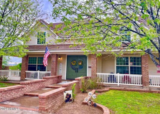 view of front of house with a front yard and a porch