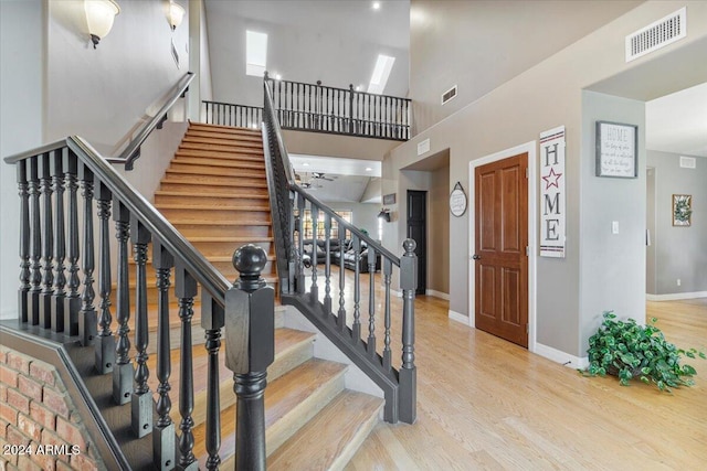 stairs featuring a high ceiling and wood-type flooring