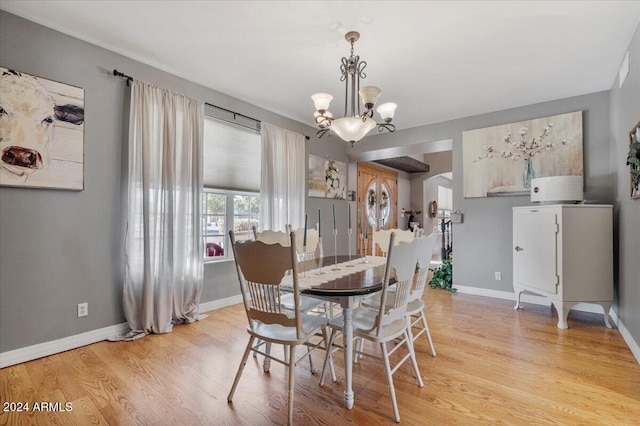 dining room with light hardwood / wood-style floors and a chandelier