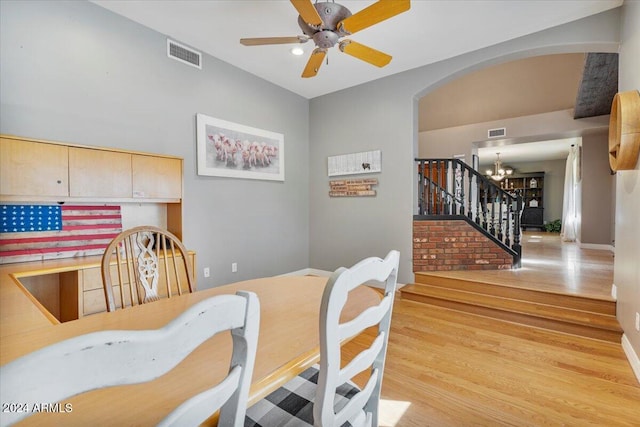 dining area featuring light hardwood / wood-style floors and ceiling fan with notable chandelier