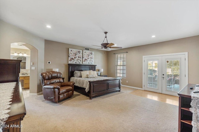 bedroom with access to outside, light colored carpet, ceiling fan, and ensuite bathroom