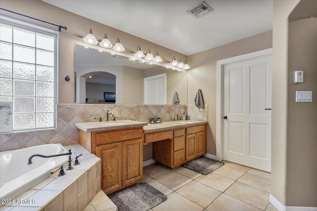 bathroom featuring vanity, tiled bath, plenty of natural light, and tile patterned floors