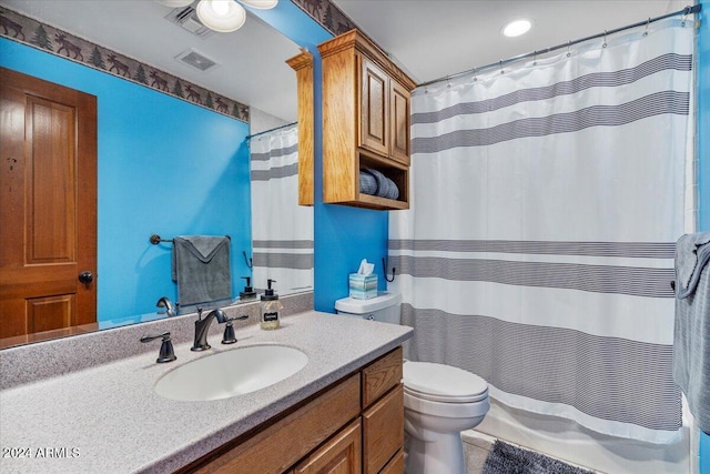 bathroom featuring curtained shower, tile patterned flooring, vanity, and toilet