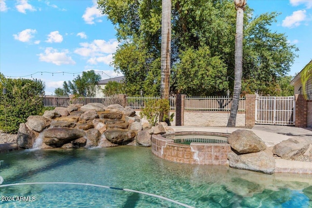 view of swimming pool featuring an in ground hot tub