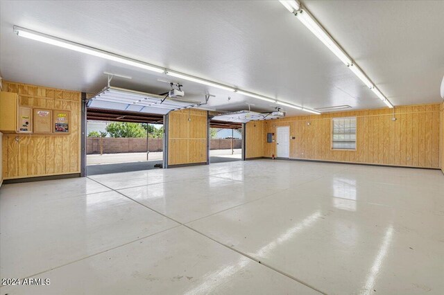 garage featuring a garage door opener and wooden walls