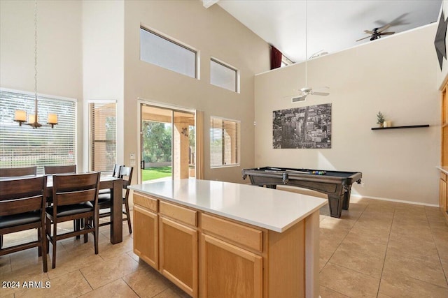 kitchen with pool table, hanging light fixtures, a high ceiling, and a kitchen island