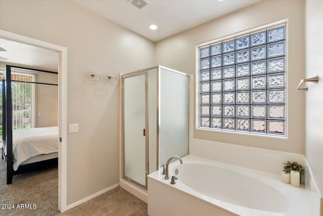 bathroom featuring tile patterned flooring, plus walk in shower, and a wealth of natural light