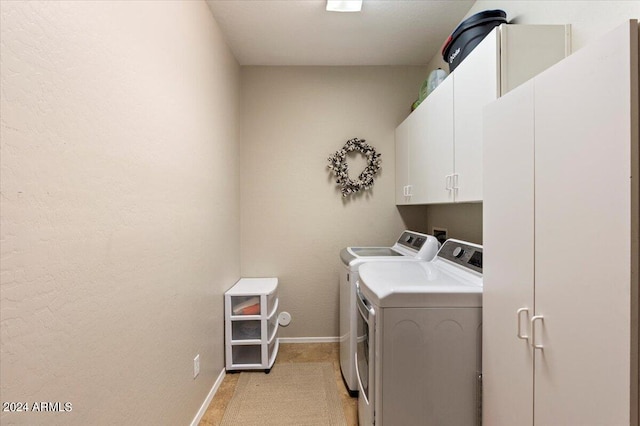 laundry room featuring cabinets and washer and clothes dryer