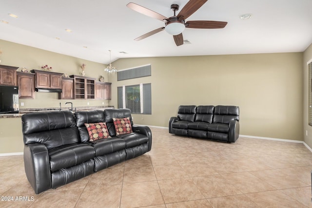 living room featuring ceiling fan with notable chandelier, light tile patterned flooring, lofted ceiling, and sink