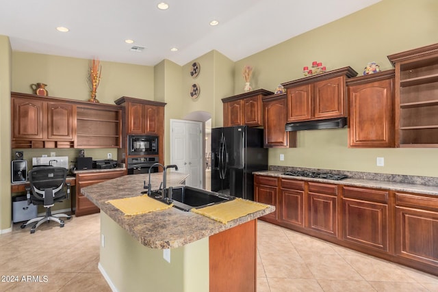 kitchen featuring a high ceiling, black appliances, a center island with sink, sink, and light tile patterned flooring