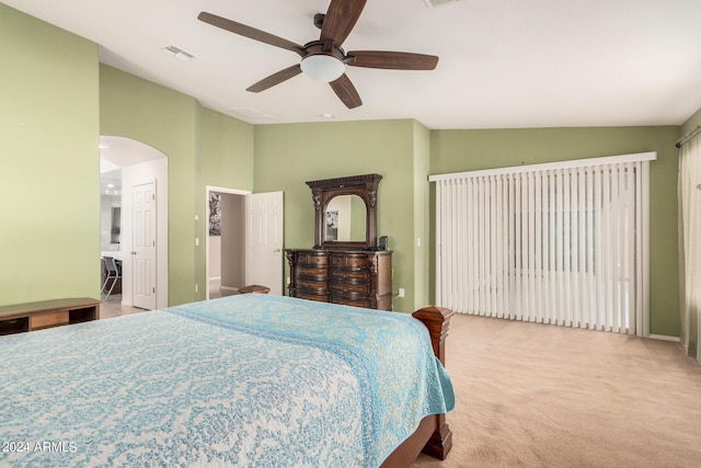 bedroom with light colored carpet, vaulted ceiling, and ceiling fan