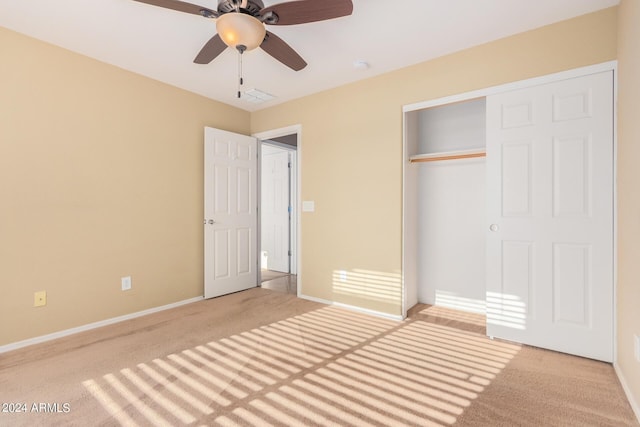 unfurnished bedroom with ceiling fan, a closet, and light carpet