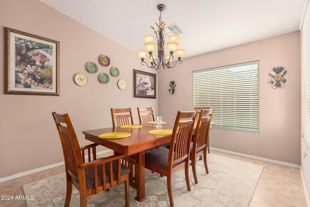 dining space with light tile patterned floors and an inviting chandelier