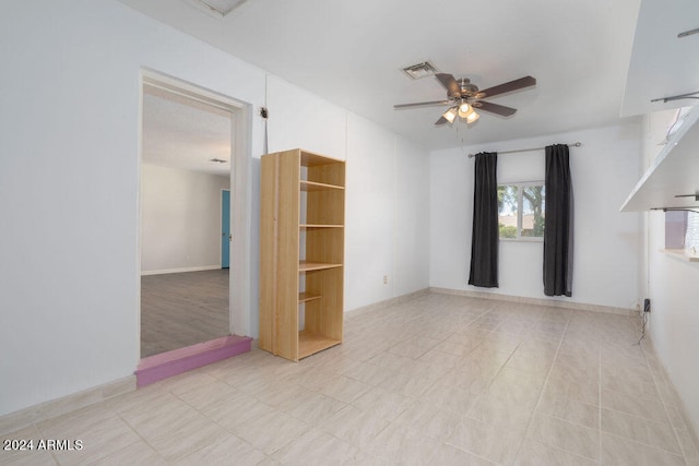 spare room featuring ceiling fan and light tile patterned floors