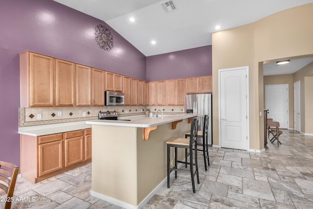 8809 S 21st St, Phoenix, AZ 85042 - kitchen with high vaulted ceiling, visible vents, light countertops, stainless steel appliances, and decorative backsplash