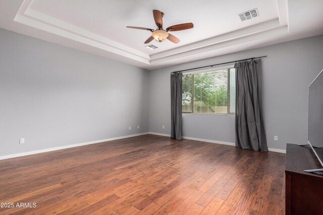 8809 S 21st St, Phoenix, AZ 85042 - spare room featuring visible vents, wood finished floors, a ceiling fan, and a raised ceiling
