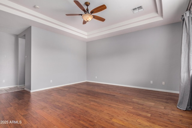 8809 S 21st St, Phoenix, AZ 85042 - spare room featuring baseboards, visible vents, a tray ceiling, ceiling fan, and hardwood / wood-style flooring