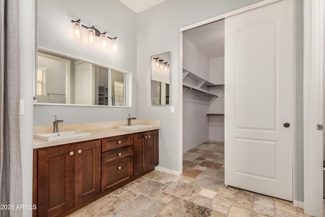 8809 S 21st St, Phoenix, AZ 85042 - full bathroom with stone tile floors, double vanity, a sink, and baseboards