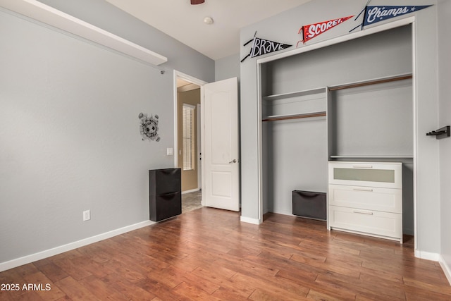 8809 S 21st St, Phoenix, AZ 85042 - unfurnished bedroom featuring wood finished floors, baseboards, and a closet