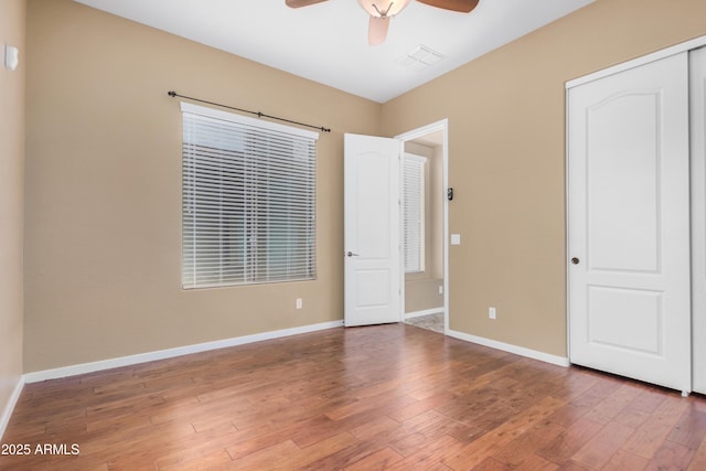 8809 S 21st St, Phoenix, AZ 85042 - unfurnished bedroom featuring visible vents, baseboards, a closet, a ceiling fan, and hardwood / wood-style flooring