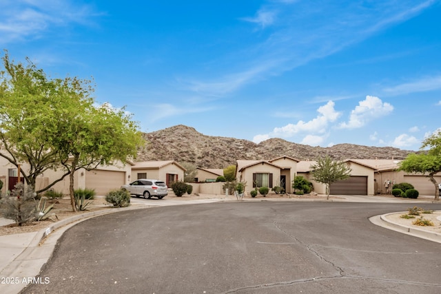 8809 S 21st St, Phoenix, AZ 85042 - view of front facade with a mountain view, an attached garage, driveway, and stucco siding