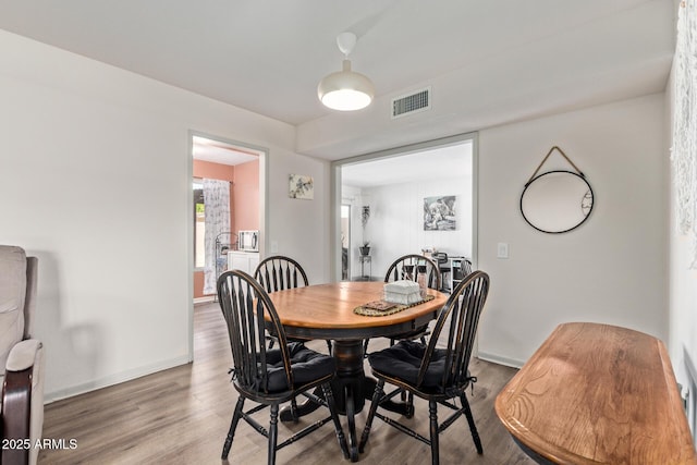 dining space featuring baseboards, visible vents, and wood finished floors