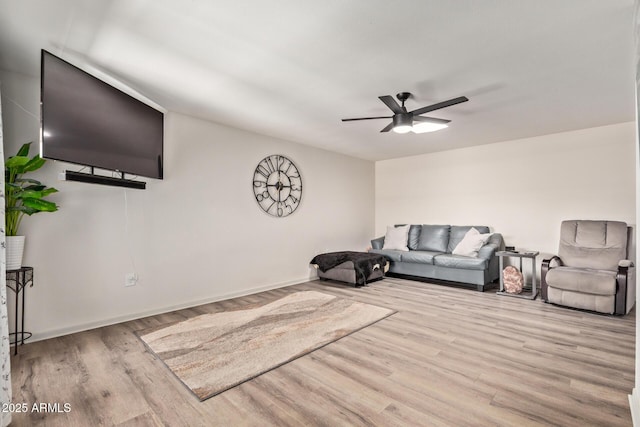 living area featuring baseboards, wood finished floors, and ceiling fan
