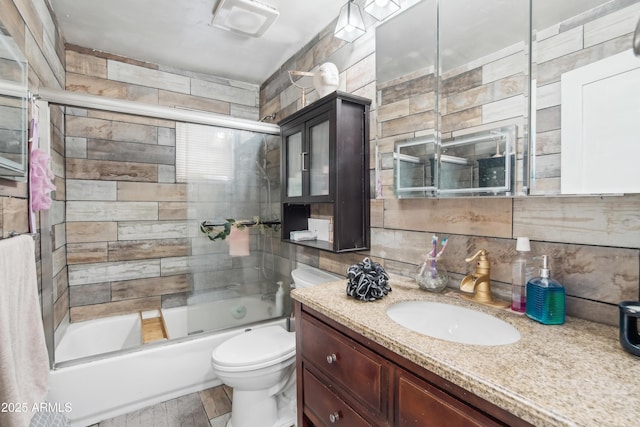 2223 E Roosevelt St, Phoenix, AZ 85006 - bathroom featuring backsplash, toilet, vanity, and shower / bath combination with glass door