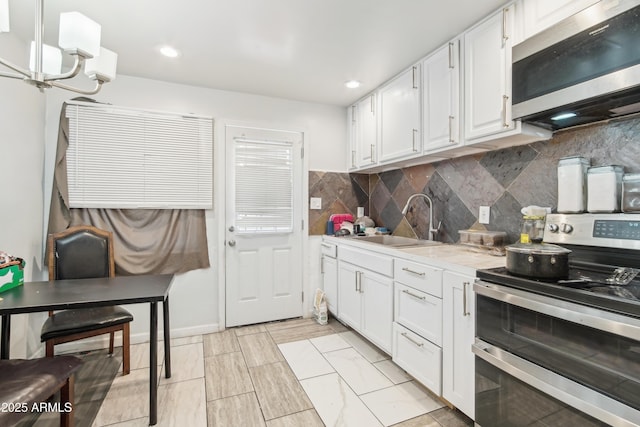 2223 E Roosevelt St, Phoenix, AZ 85006 - kitchen with a sink, stainless steel appliances, tasteful backsplash, white cabinetry, and light countertops