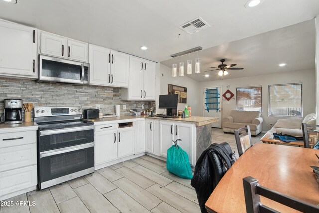 2223 E Roosevelt St, Phoenix, AZ 85006 - kitchen featuring a ceiling fan, visible vents, a peninsula, stainless steel appliances, and white cabinets