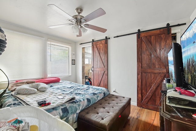 2223 E Roosevelt St, Phoenix, AZ 85006 - bedroom with baseboards, ceiling fan, light wood-style floors, and a barn door