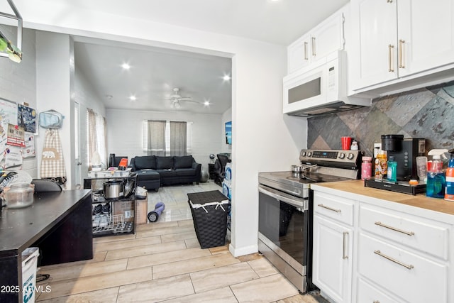 2223 E Roosevelt St, Phoenix, AZ 85006 - kitchen with white microwave, ceiling fan, white cabinetry, and stainless steel electric stove
