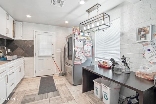 2223 E Roosevelt St, Phoenix, AZ 85006 - kitchen with a sink, freestanding refrigerator, visible vents, white cabinets, and a notable chandelier
