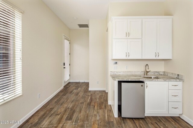 654 E County Down Dr, Chandler, AZ 85249 - kitchen featuring a sink, dark wood-style flooring, white cabinetry, light stone counters, and baseboards