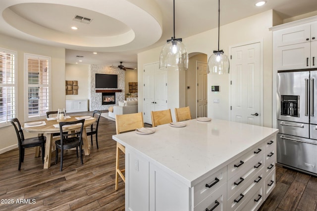 654 E County Down Dr, Chandler, AZ 85249 - kitchen with high end refrigerator, a ceiling fan, a large fireplace, dark wood-type flooring, and arched walkways