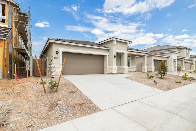 17778 W Turquoise Ave, Waddell, AZ 85355 - view of front of property featuring an attached garage, stucco siding, concrete driveway, and stone siding