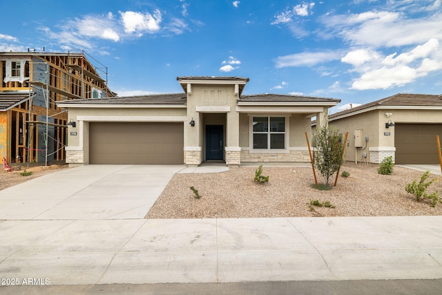 17778 W Turquoise Ave, Waddell, AZ 85355 - prairie-style home with stucco siding, a garage, stone siding, driveway, and a tiled roof