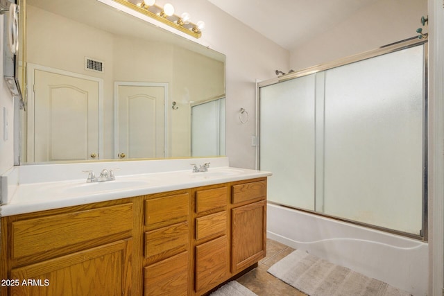 bathroom featuring tile patterned flooring, vanity, and combined bath / shower with glass door