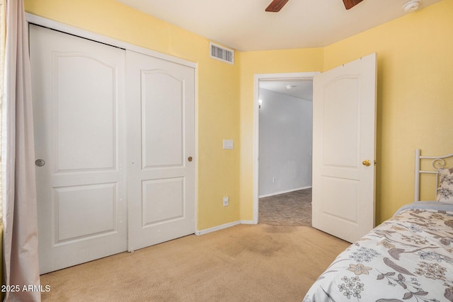 carpeted bedroom featuring ceiling fan and a closet