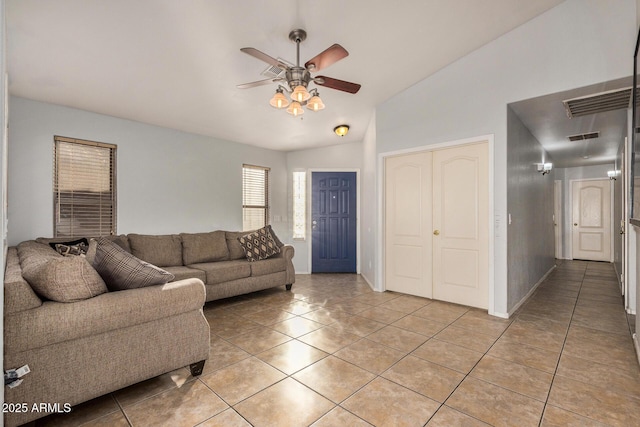 tiled living room featuring ceiling fan and lofted ceiling