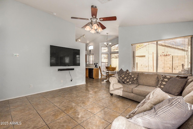 tiled living room featuring sink, ceiling fan with notable chandelier, and lofted ceiling