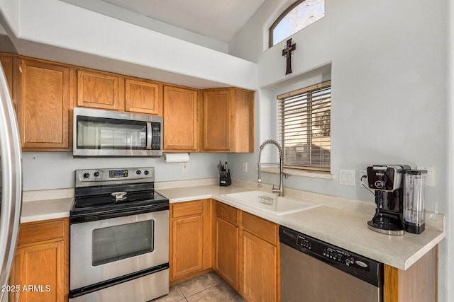 kitchen featuring sink, light tile patterned floors, and stainless steel appliances