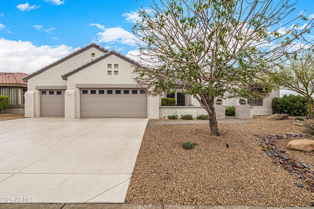 view of front of home featuring driveway, a tiled roof, a garage, and stucco siding