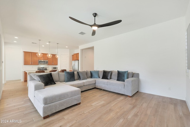 living room featuring light hardwood / wood-style floors and ceiling fan