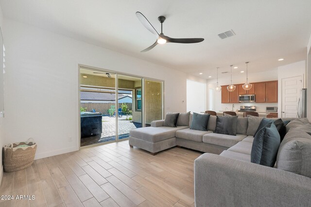 living room featuring light wood-type flooring and ceiling fan