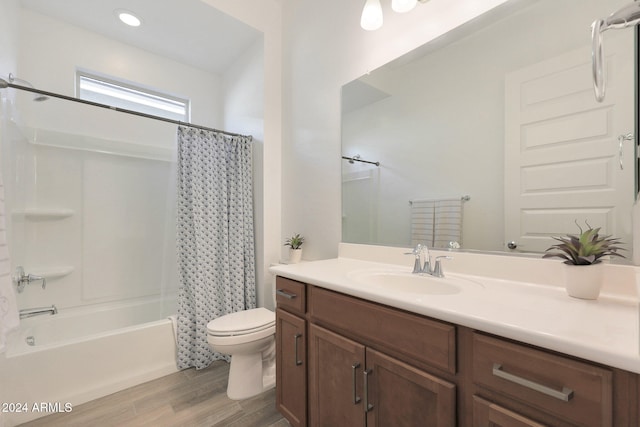 full bathroom featuring wood-type flooring, shower / bath combo with shower curtain, toilet, and vanity